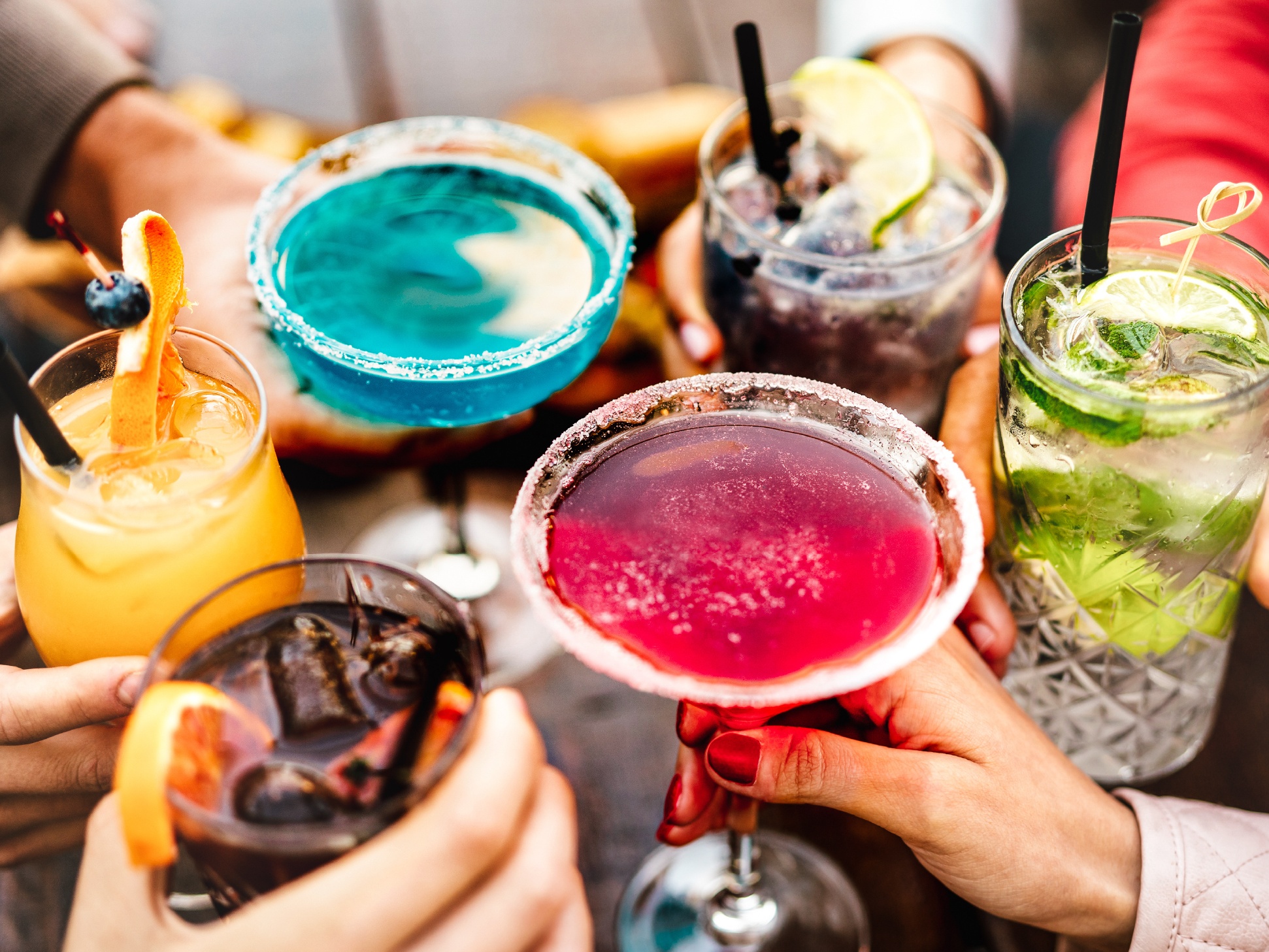 Diversas bebidas coloridas como sucos, refrigerantes e drinks em um restaurante